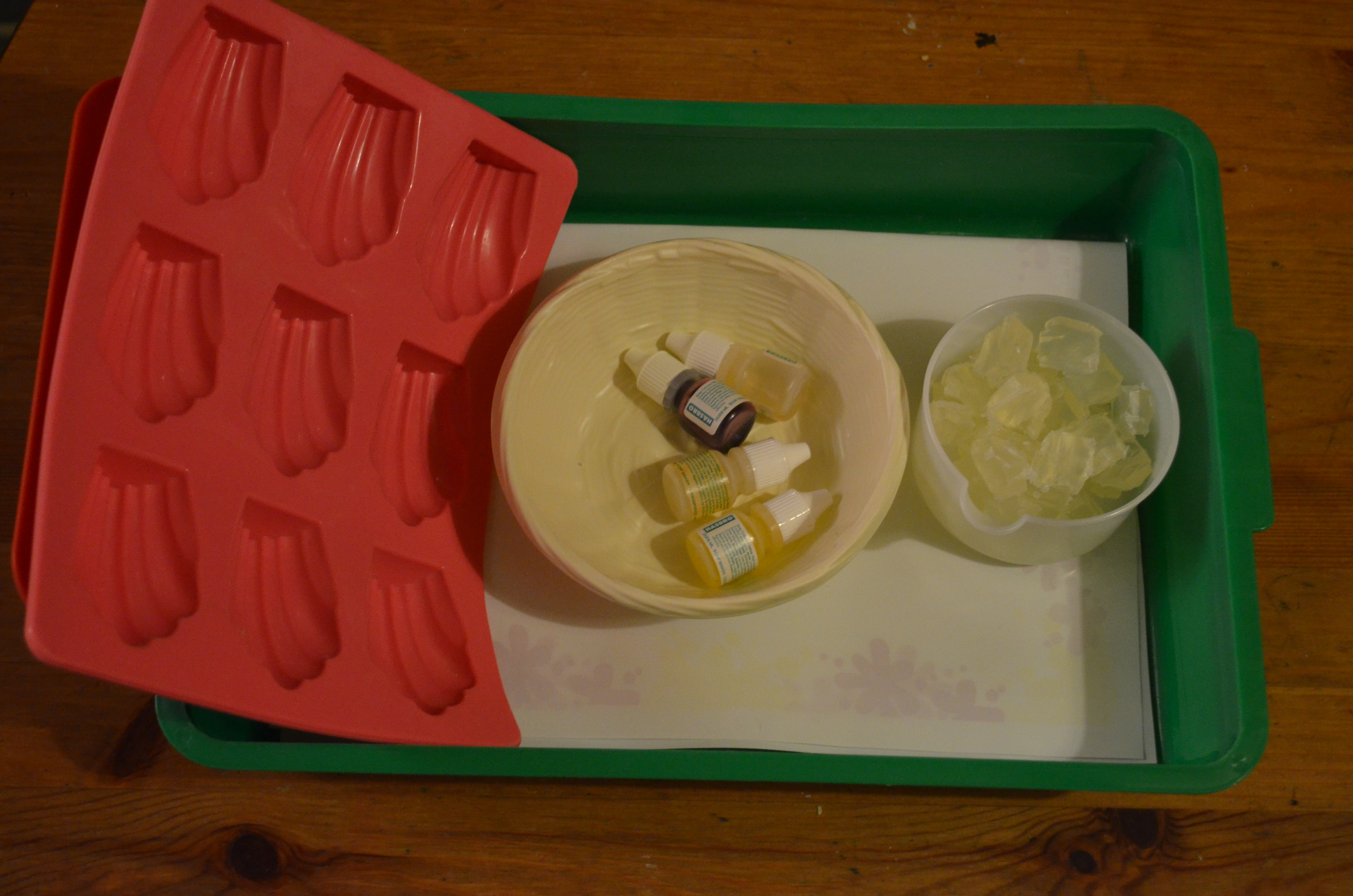Cut up soap bits to melt in hot water, a basket of dyes and scents and shell and star shaped molds