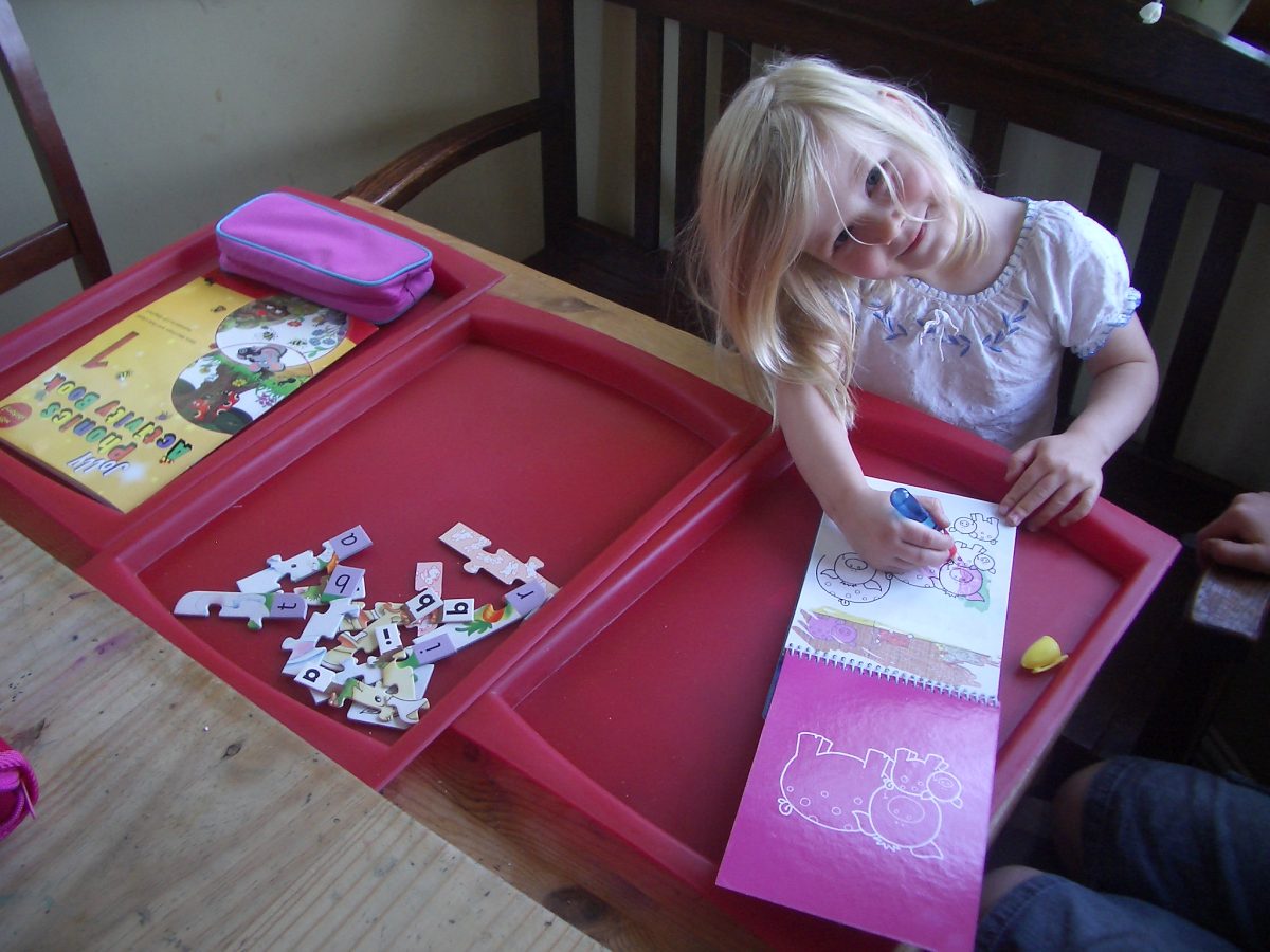 Little girl with learning trays