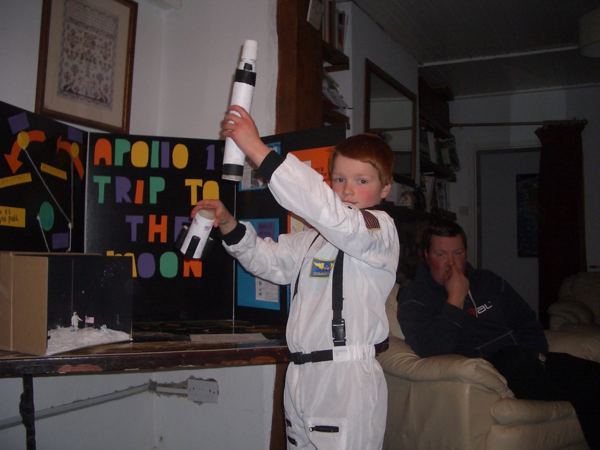 Boy dressed as astronaut giving astronomy presentation